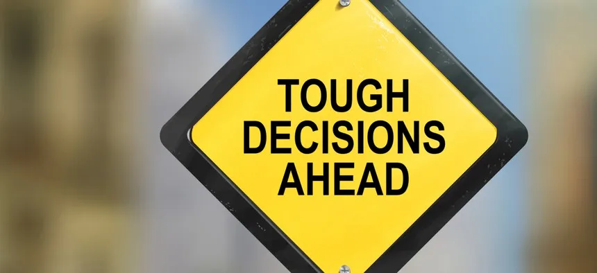 A sign reading 'tough decisions ahead'