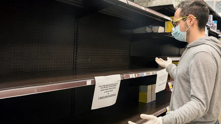 A guy staring at an empty supermarket isle