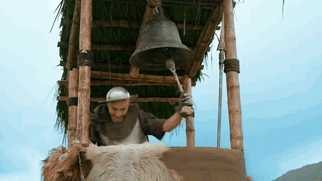 A medieval guard ringing a bell